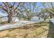 Expansive backyard featuring a driveway, detached garage, and lush greenery beneath mature trees at 5744 150Th N Ave, Clearwater, FL 33760