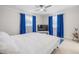 Bright bedroom showcasing a tray ceiling, white bedding, and modern blue curtains at 5744 150Th N Ave, Clearwater, FL 33760