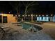 Night view of the in-ground pool and spacious brick patio with lounge chairs and outdoor string lights at 5744 150Th N Ave, Clearwater, FL 33760