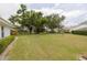 A view of the backyard, showcasing the well-maintained lawn and the exterior of neighboring homes at 5812 Garden Lakes Majestic, Bradenton, FL 34203