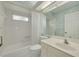 The bathroom features a shower-tub combo with white tile and a vanity with a large mirror at 5812 Garden Lakes Majestic, Bradenton, FL 34203