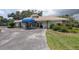 Exterior view of the clubhouse with a blue awning, well-maintained landscaping, and inviting entrance at 5812 Garden Lakes Majestic, Bradenton, FL 34203