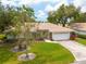 Well-maintained home with a tile roof, lush green lawn, and a two-car garage, offering great curb appeal at 5812 Garden Lakes Majestic, Bradenton, FL 34203