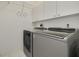 A laundry room featuring white cabinets and modern washer and dryer units at 5812 Garden Lakes Majestic, Bradenton, FL 34203