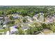 Aerial view of the neighborhood highlighting mature trees, a pond and the property at 5905 Berkford Dr, Holiday, FL 34690