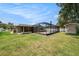 Expansive lawn and backyard showcasing the pool, hot tub, and screened-in lanai at 5905 Berkford Dr, Holiday, FL 34690