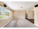 Bright living room features large window with blinds and neutral carpet at 5905 Berkford Dr, Holiday, FL 34690