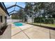 Screened-in pool area with a kidney-shaped pool, hot tub, and a storage shed at 5905 Berkford Dr, Holiday, FL 34690
