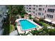 Aerial view of inviting community pool nestled between residential buildings and lush landscaping at 6190 80Th N St # 102, St Petersburg, FL 33709