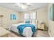 Cozy bedroom featuring a ceiling fan, a dresser, and a queen-size bed with bright blue accents at 6190 80Th N St # 102, St Petersburg, FL 33709