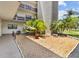 Exterior view of the building highlighting landscaped grounds and mature palm trees at 6190 80Th N St # 102, St Petersburg, FL 33709