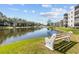 Relax on the bench by a serene pond with lush greenery and beautiful building views at 6190 80Th N St # 102, St Petersburg, FL 33709