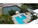 Aerial view of a community pool, tennis courts and shuffleboard courts surrounded by trees and landscaping at 6190 80Th N St # 102, St Petersburg, FL 33709