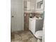 Bathroom featuring vanity with storage, a toilet, neutral tile floors, and a framed mirror at 7524 Oakshire Dr, Port Richey, FL 34668