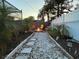 Backyard fire pit with gravel pathway, tropical landscaping, and string lights at 821 Karen St, Palm Harbor, FL 34684