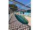 Screened pool with white vinyl lattice enclosure and poolside seating at 821 Karen St, Palm Harbor, FL 34684