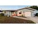 Charming single-story home with a well-manicured lawn, landscaping, and attached garage at 821 Karen St, Palm Harbor, FL 34684