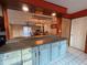 Kitchen features updated cabinets, countertop bar and pot rack, creating a functional and stylish space at 821 Karen St, Palm Harbor, FL 34684