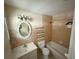 Bathroom featuring a tub, toilet, vanity, mirror, and wall-mounted storage shelves at 8503 N Willow Ave, Tampa, FL 33604