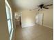 Bedroom with tile floors, ceiling fan, window, and doorway leading to a bathroom at 8503 N Willow Ave, Tampa, FL 33604