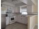 Well-lit kitchen with white cabinetry, stainless steel appliances, and a breakfast bar at 8503 N Willow Ave, Tampa, FL 33604