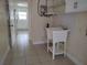 Bright laundry room features durable flooring, sink, cabinets, and connections for washer and dryer at 8503 N Willow Ave, Tampa, FL 33604