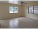 Spacious living room featuring tile floors, ceiling fan, and large windows that let in ample natural light at 8503 N Willow Ave, Tampa, FL 33604