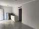 Open living area with kitchenette featuring neutral walls and tiled floors at 8503 N Willow Ave, Tampa, FL 33604