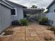Paver patio, covered parking, landscaping, and bench on side of light-blue home at 8503 N Willow Ave, Tampa, FL 33604