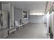 Covered patio with tile floors, chairs, storage area, and a refrigerator at 8503 N Willow Ave, Tampa, FL 33604