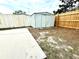 Backyard with a utility shed, some mature trees, and a concrete patio area at 9005 Rainbow Ln, Port Richey, FL 34668