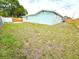 Spacious backyard with a well-maintained lawn, wood fencing, and mature trees at 9005 Rainbow Ln, Port Richey, FL 34668
