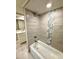 Updated bathroom featuring a tiled shower with a rainfall shower head and decorative accent tiling at 9005 Rainbow Ln, Port Richey, FL 34668