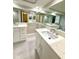 Bathroom featuring double sinks, a quartz countertop, large mirrors and modern fixtures at 9005 Rainbow Ln, Port Richey, FL 34668