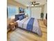 Well-lit bedroom with a ceiling fan, closet, and a comfortable bed with blue accents at 9005 Rainbow Ln, Port Richey, FL 34668