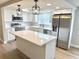 Modern kitchen featuring white cabinets, stainless steel appliances, and a large island with quartz countertops at 9005 Rainbow Ln, Port Richey, FL 34668