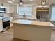 Modern kitchen featuring white cabinets, stainless steel appliances, and a large island with quartz countertops at 9005 Rainbow Ln, Port Richey, FL 34668