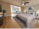 Spacious main bedroom with a ceiling fan, soft blue accents, and a view into the living area at 9005 Rainbow Ln, Port Richey, FL 34668