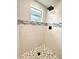 Updated shower with white subway tile, decorative accent strip and mosaic tile flooring at 9005 Rainbow Ln, Port Richey, FL 34668