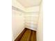 Well-organized walk-in closet with wood flooring and multiple shelving units for optimal storage at 9005 Rainbow Ln, Port Richey, FL 34668