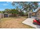 Large fenced backyard featuring a shed, covered patio, and mature trees at 9043 108Th Ave, Seminole, FL 33777