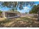 Large backyard featuring mature trees, a fenced perimeter, and a covered patio at 9043 108Th Ave, Seminole, FL 33777