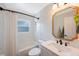 Clean bathroom featuring white subway tile, black fixtures, and a gold framed mirror at 9043 108Th Ave, Seminole, FL 33777