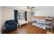 Charming bedroom with a bunk bed, a blue armchair, and a window with curtains at 9043 108Th Ave, Seminole, FL 33777