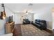Bright living room with a black leather sofa, hardwood floors, and a large area rug at 9043 108Th Ave, Seminole, FL 33777