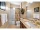 Bathroom with a marble countertop, white sink, and a shower with a tub at 9208 Brindlewood Dr, Odessa, FL 33556