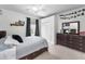 Well-lit bedroom featuring a comfortable bed, dresser, and photo decorations at 9208 Brindlewood Dr, Odessa, FL 33556