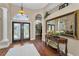Inviting foyer with wood floors, decorative mirror and table, and arched doorways at 9208 Brindlewood Dr, Odessa, FL 33556