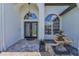Elegant front entryway with decorative glass doors, stone landscaping, and a charming tiered fountain at 9208 Brindlewood Dr, Odessa, FL 33556