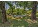 Comfortable hammock with striped design, strung between mature trees in a serene backyard setting at 9208 Brindlewood Dr, Odessa, FL 33556